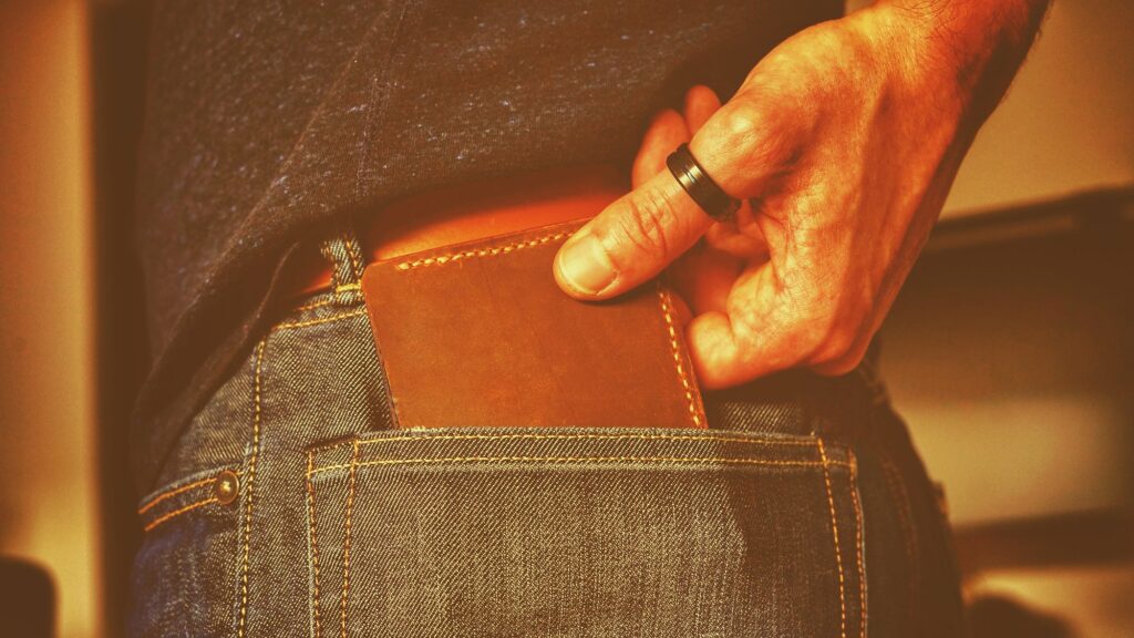 person holding black and brown leather bag