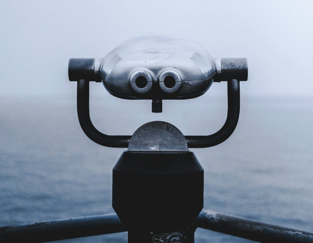 selective focus photography of grey coin operated telescope