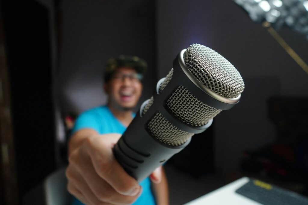 man in blue and black crew neck t-shirt holding microphone