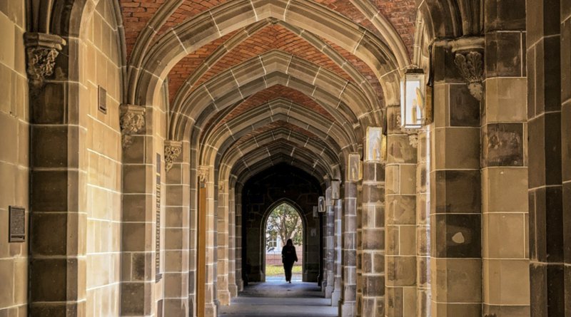 a man is walking down an archway in a building