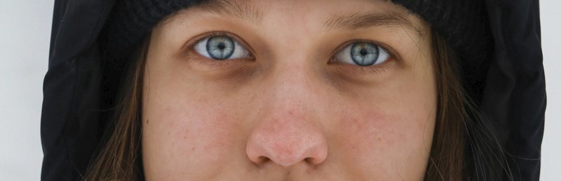 a woman with blue eyes wearing a black hat