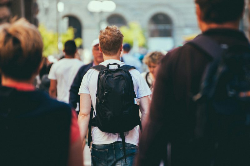 man in black and white shirt carrying black backpack