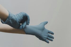 person in blue gloves and blue denim jeans