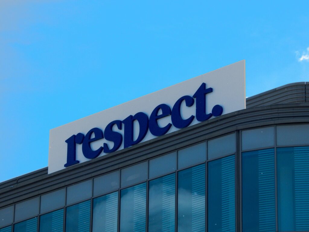 A building with a "respect." sign against a blue sky.