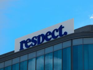 A building with a "respect." sign against a blue sky.