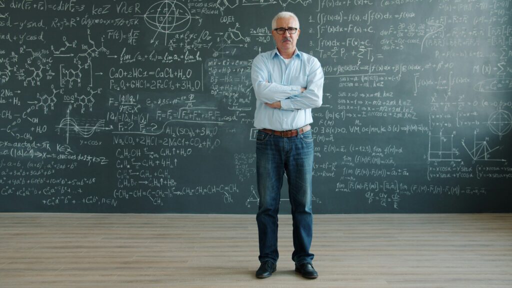Man stands in front of chalkboard with complex equations