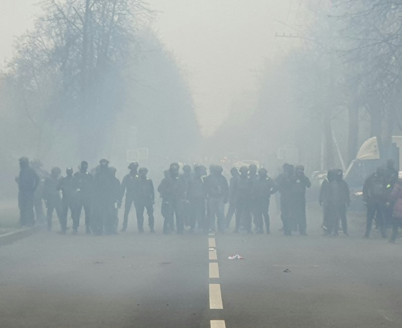 a group of people standing on the side of a road