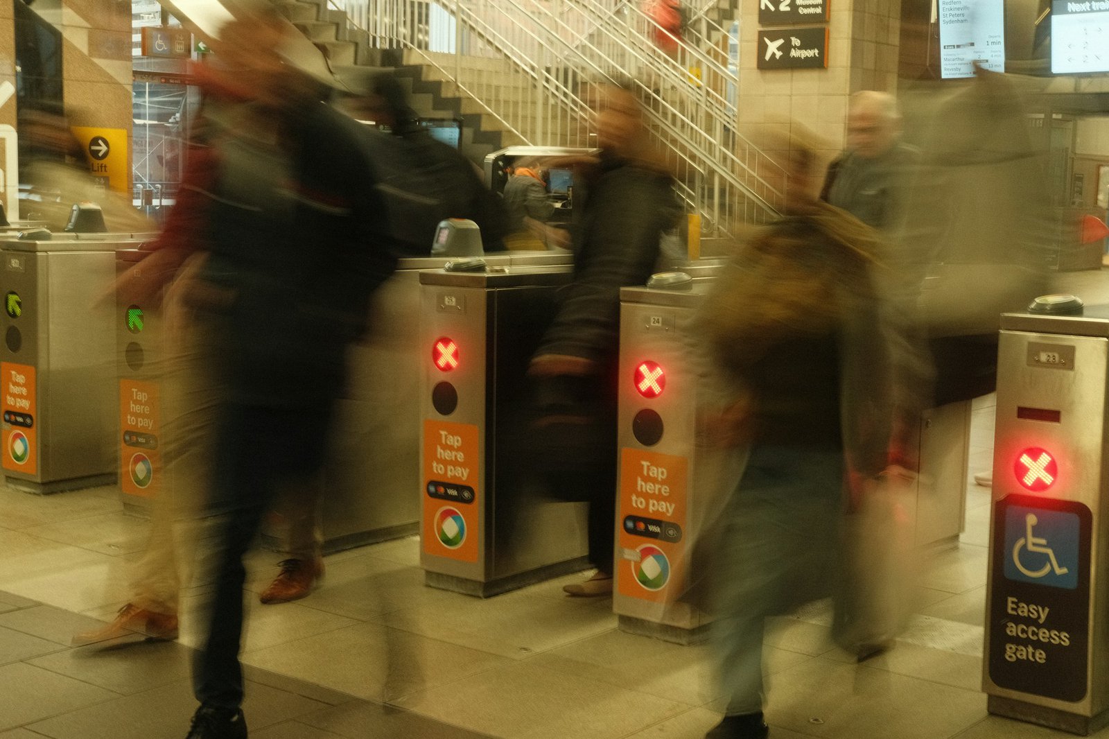 Blurred people moving through subway turnstiles in a busy station
