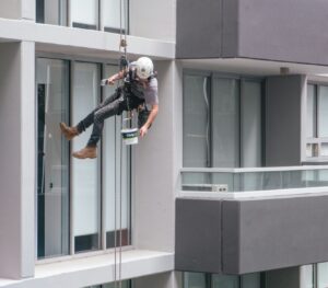 man in black jacket and black pants jumping on window during daytime