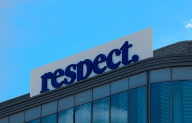 A building with a "respect." sign against a blue sky.