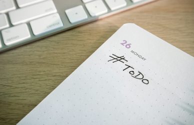 a close up of a notepad with a keyboard in the background
