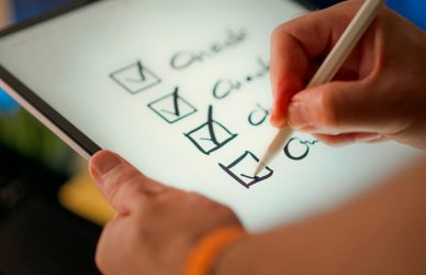 A hand marks off items on a checklist.
