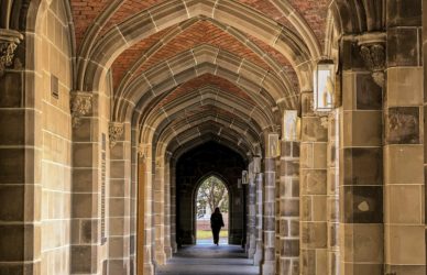 a man is walking down an archway in a building