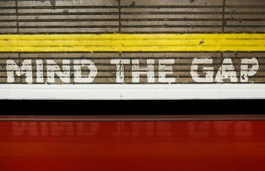 A sign that says mind the gap on the side of a train