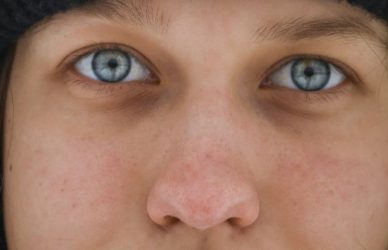 a woman with blue eyes wearing a black hat