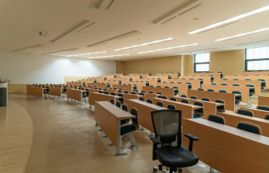 black swivel chair beside rectangular brown wooden desk