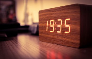 brown wooden table with digital clock at 12 00