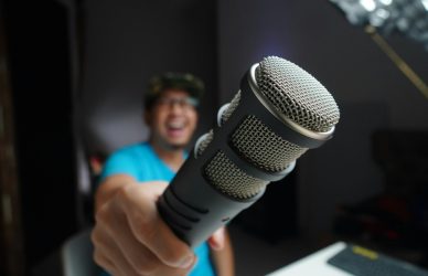 man in blue and black crew neck t-shirt holding microphone