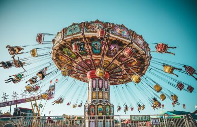 photograph of people riding swing carousel