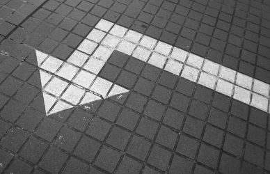 white arrow on bricked pavement